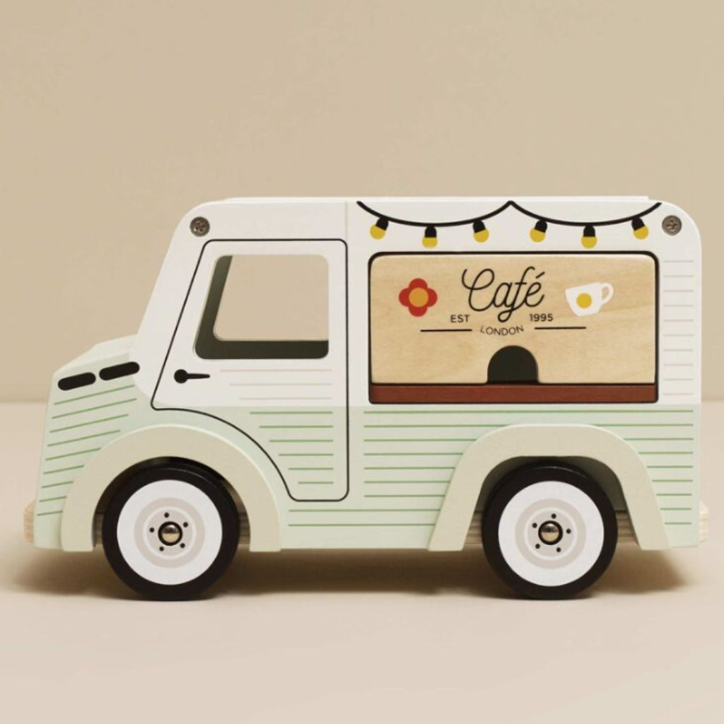 Side of toy van with 'Café London' sign on a beige background